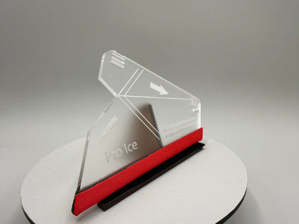 Clear ice scraper with red handle on a gray background