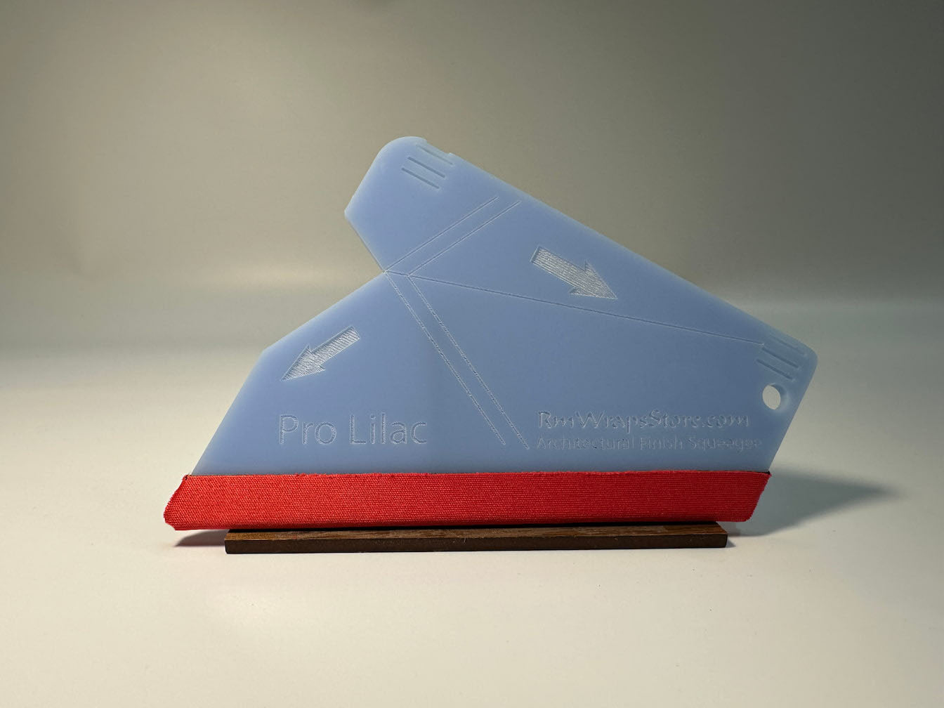 Acrylic squeegee with a red microfiber felt surface, featuring guide arrows and a lanyard hole, positioned on a white background.