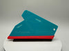 Turquoise and red squeegee on a white platform with a gray background