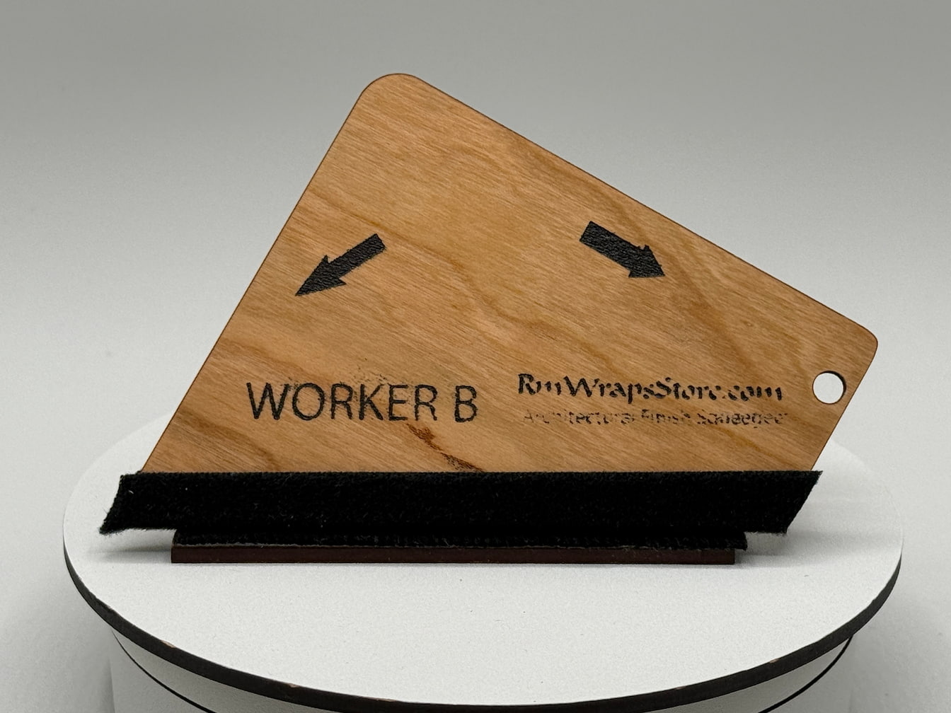Wooden nameplate with 'WORKER B' engraved on a white stand against a gray background