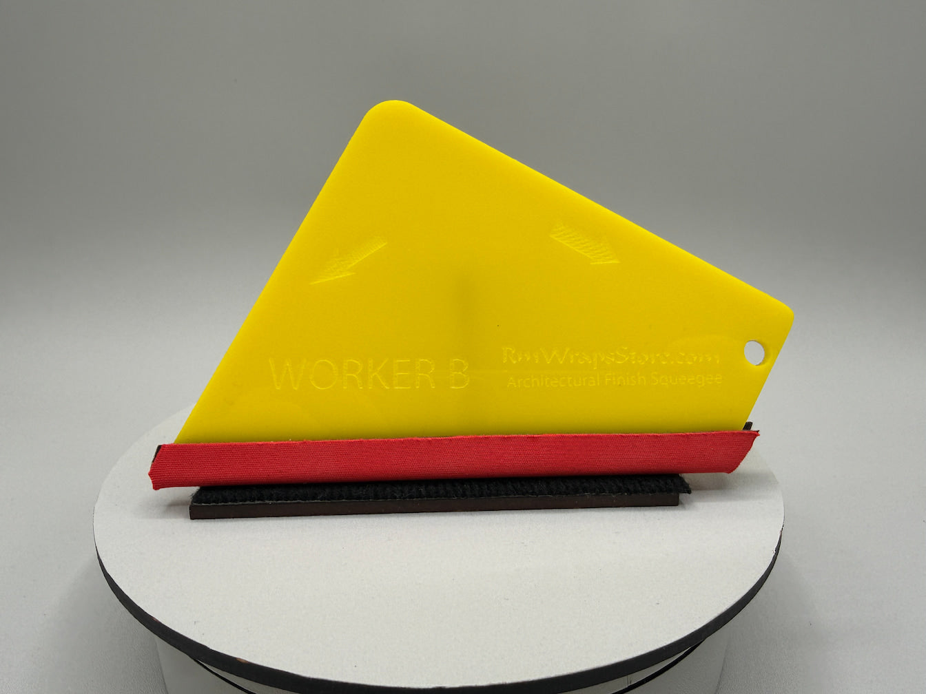 Yellow and red tool on a white stand with a gray background