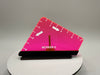Pink triangular ruler with measurement markings on a gray background