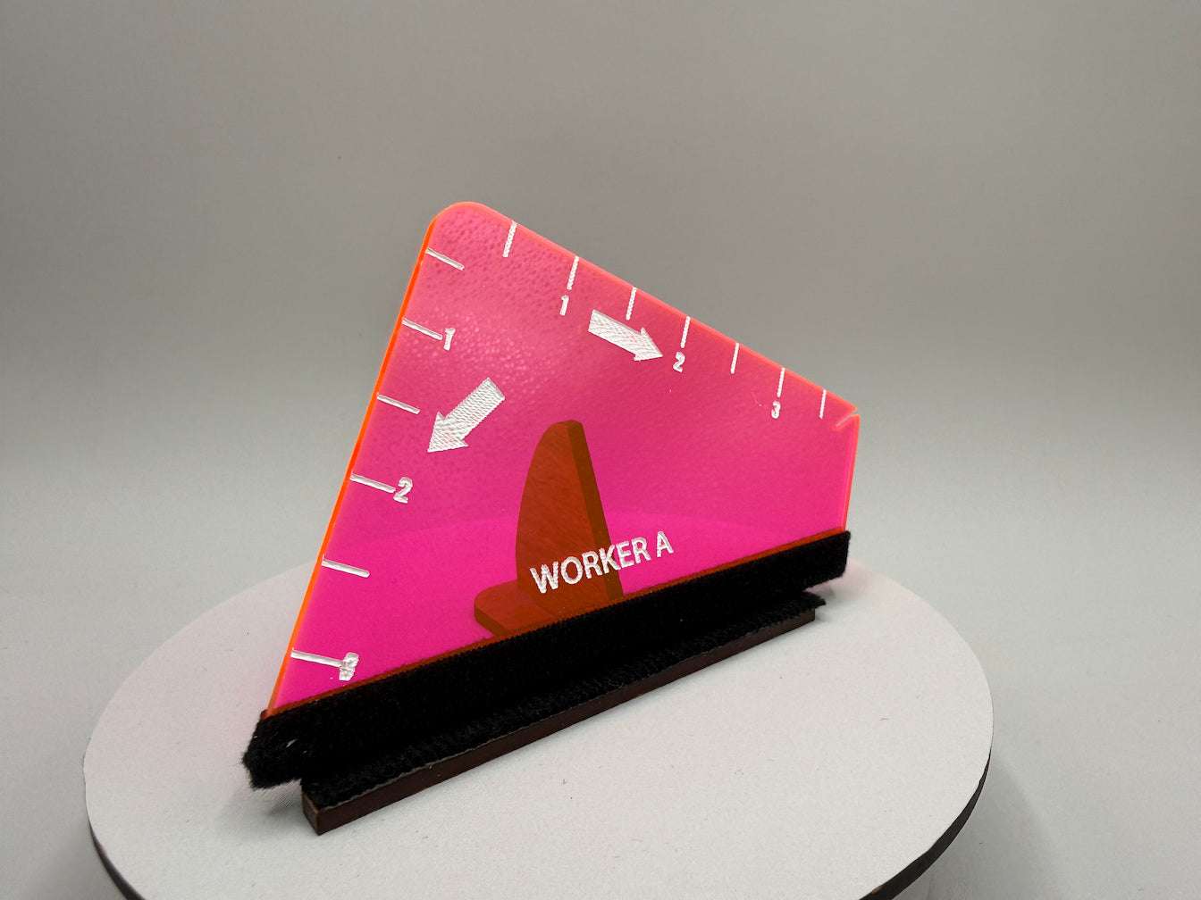 Pink triangular sign with a brown traffic cone and 'WORKER A' text on a gray background