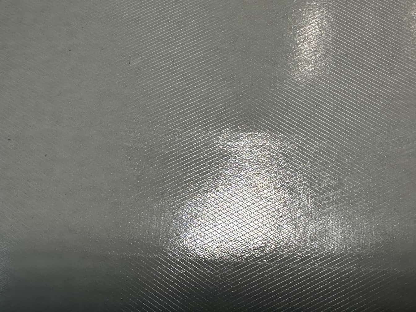 Close-up of textured gray surface with light reflection