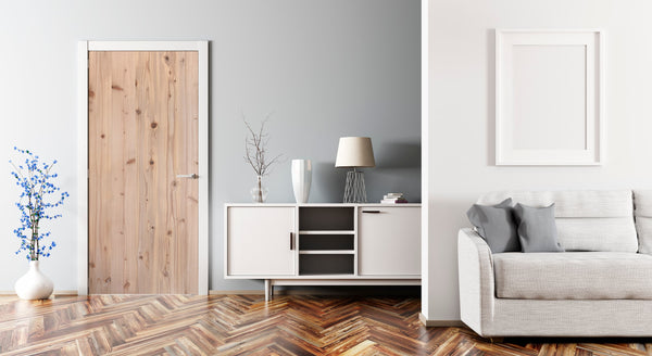 Modern living room with a gray sofa, wooden floor, and white walls.