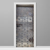 Decorative door with metal studs and a white frame on a gray wall.