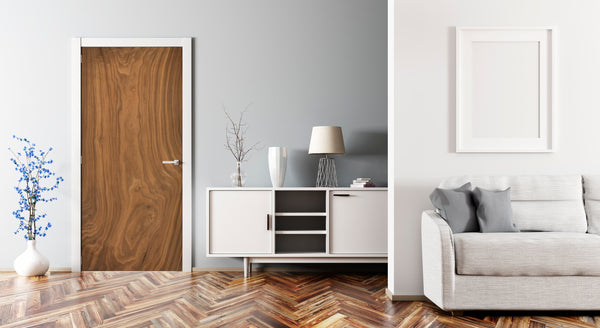Modern living room with wooden door, white cabinet, and gray sofa.